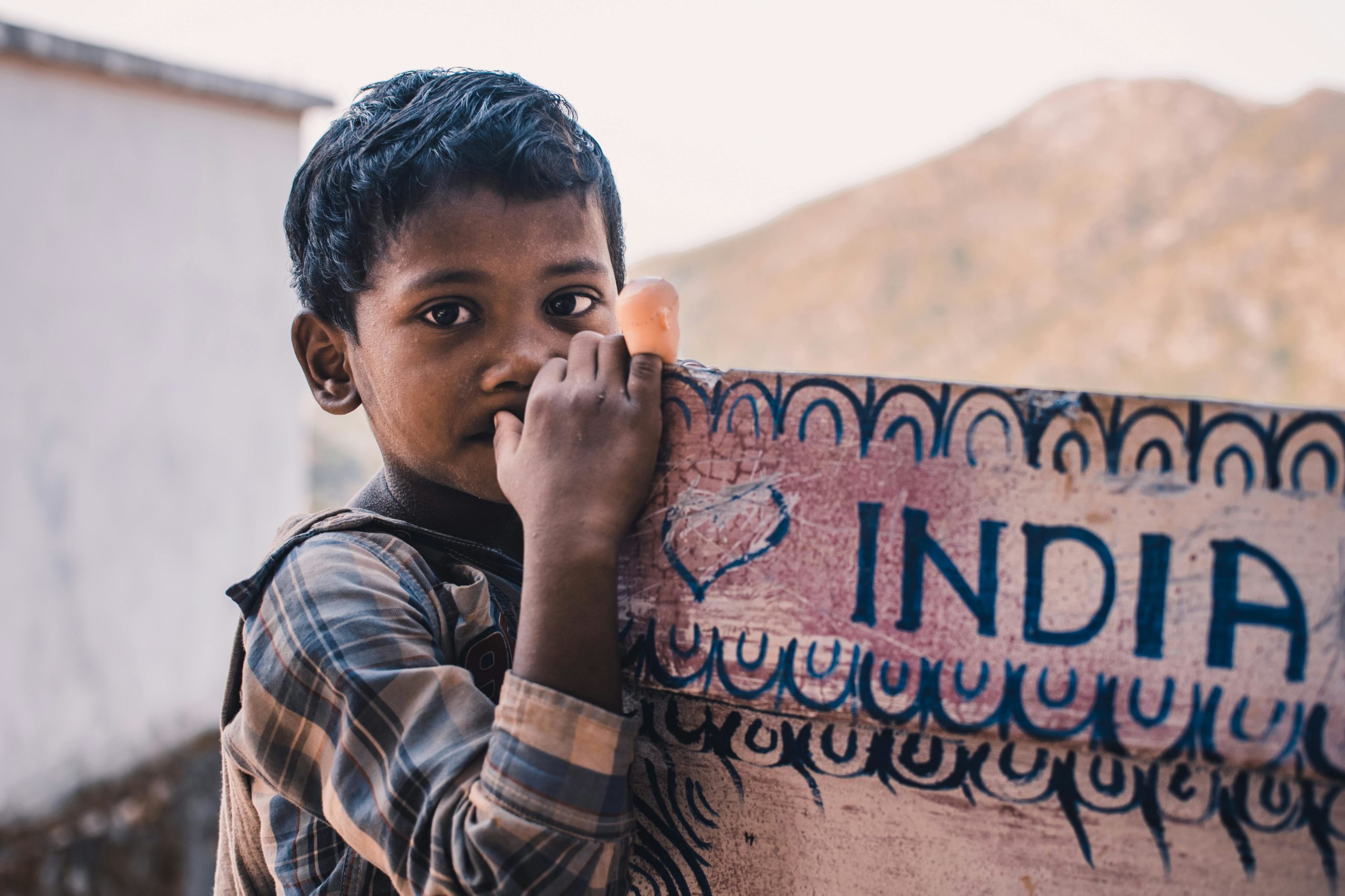 Enfant tenant un tapis avec marqué India dessus
