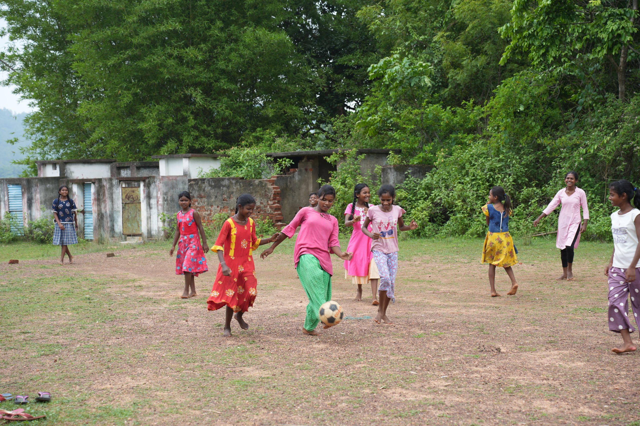 Jeunes filles jouant au foot dehors.